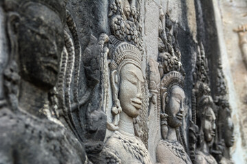 Fototapeta premium Detail of a Stone Carved Relief in the famous Angkor Wat in Cambodia and the largest religious monument in the world. Location: Siem Reap, Cambodia. Artistic picture. Beauty world.