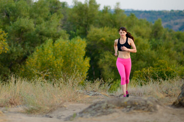 Young Woman Running on the Morning Mountain Trail. Active Lifestyle Concept.