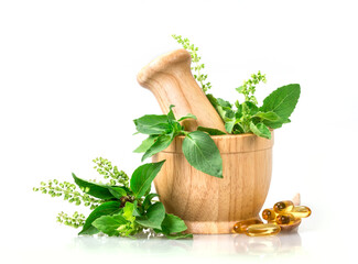 Sweet basil and hot basil in wooden mortar with essential oil and supplement, alternative herbal...