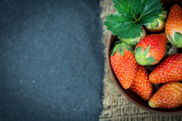Close up Top view of Red Strawberries and leaf with black stone background