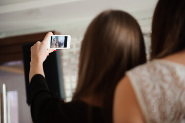 Three young girls are doing selfie photo in a restaurant