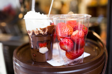 Fruit salad arranged in plastic cups for sale. refrigerator showcase or buffet. Used in cocktails and as a topping to the chocolate fountain. Selective focus