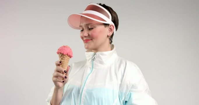 pretty woman in sun visor eats an ice cream