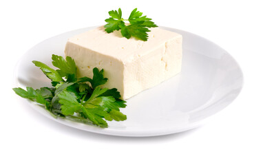 Part of Bryndza on the white plate with greens. Isolated