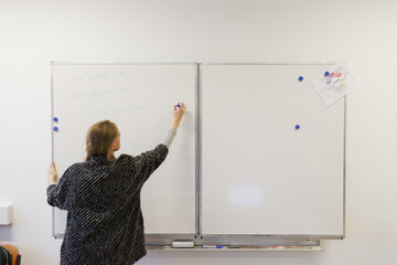 a teacher writing on a white board