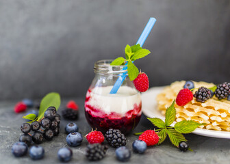 Yogurt with fresh berries fruit and crispy wafers on stone background.