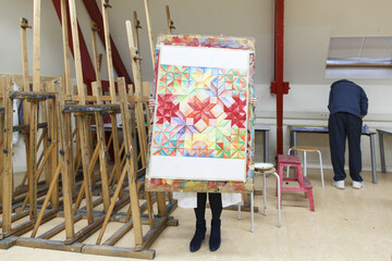 a high school student holding up a painting made at creative lessons