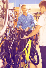 Fototapeta na wymiar father with son choosing bike in store.