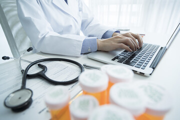 Female doctor is typing in laptop computer