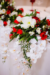 Gorgeous bouquet of orchid and roses on newlyweds table