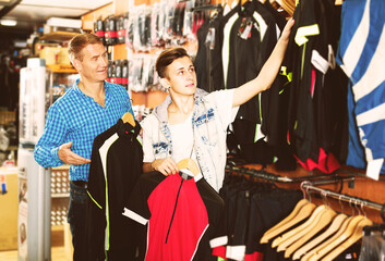 Positive father and his son choosing sport clothing