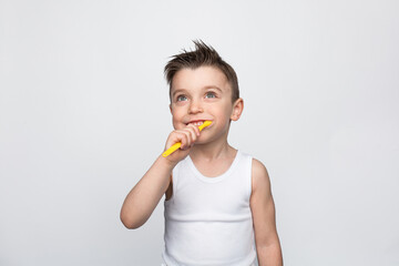 Small kid brushing teeth on white