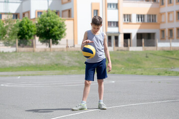 Teenager in a T-shirt and shorts playing with a ball