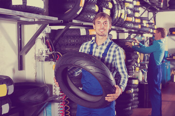 Obraz na płótnie Canvas Working man standing with new tires