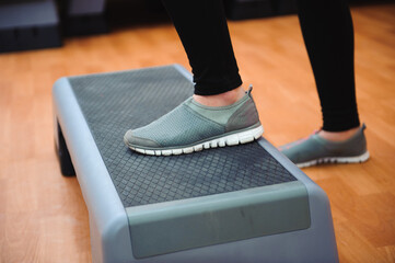 Athletic woman trainer doing aerobic class with steppers. Sport and health concept.