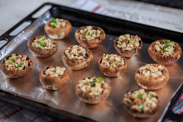 The champignons stuffed with chicken and greens under cheese on a foil