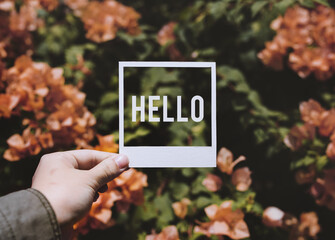 People Hand Holding Hello Photo Frame with Bougainvillea Background © Rawpixel.com