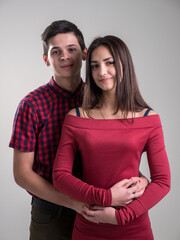 Happy young couple embrace each other, being happy, in a white background studio