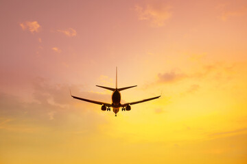 Flying airplane preparing to landing over sunset sky