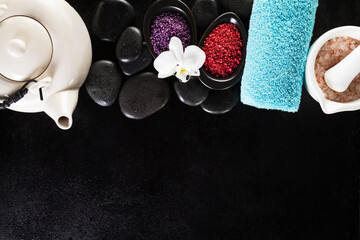 Beautiful Spa Set Spa Products with Essential Oils, Soap, Towel, Spa Sea Salt on Dark Wet Background. Horizontal with Copy Space.