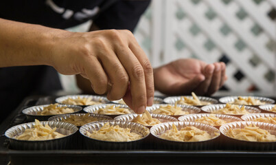 Obraz na płótnie Canvas chef sprinkle Almond on banana cake for prepare to go in oven.