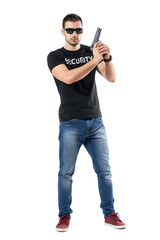 Ready alerted undercover officer holding gun in both hands looking at camera.  Full body length  portrait isolated on white studio background.