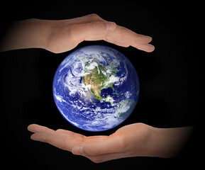 Glowing earth globe in hands on black background, environment concept - elements of this image furnished by NASA