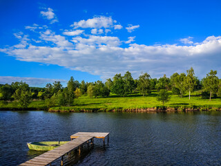 Fototapeta premium Background of nature landscape with clouds and lake with boat
