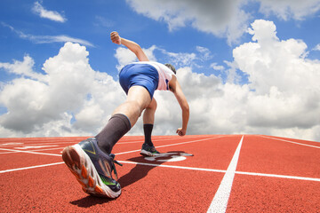Feet runner on start line ready for a sprint start running on track with blue sky background. sport...