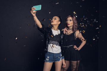 Beautiful young stylish women taking selfie with smartphone and smiling