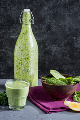fresh antioxidant drink, bowl of spinach, parsley and piece of lemon on tabletop