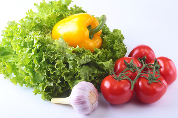 Fresh assorted vegetables bell pepper, tomato, garlic with leaf lettuce. Isolated on white background. Selective focus.