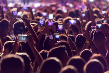 Hand with a smartphone records live music festival