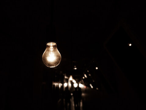 Hanging light bulb in darkness