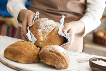 Female hand holding hot freshly baked bread