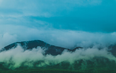 Photo depicting beautiful a foggy mystic mountains. Fog clouds at the pine tree mystical woods, morning. Europe, mysterious alps landscape.
