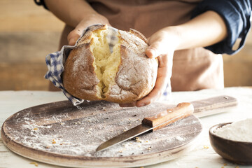 Female hand holding hot freshly baked bread