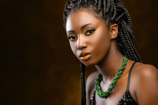 Studio portrait of attractive african woman with braids.