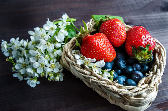 Wicker bowl with blueberries and strawberries. Still-life. Gardening, floriculture, food industry, tea packing, restaurant business