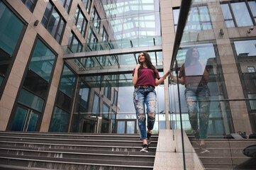 outdoor portrait of a stylish woman on the steps of shopping mall