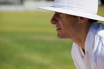 Side view of focused umpire at field during cricket match