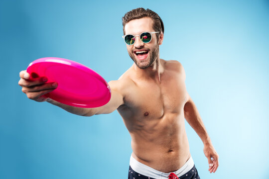 Active Young Man In Summer Clothes Throwing Frisbee Disc