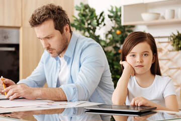 Loving daughter sitting near her busy father