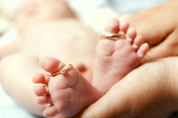 Legs of an infant with wedding rings.