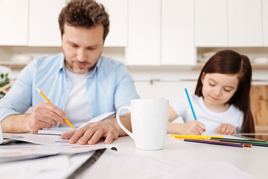 Father and his daughter drawing with pencils