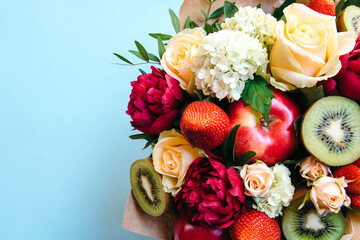 The original edible bouquet of marshmallow, apples, strawberries and flowers on blue
