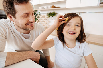 Girl holding a piece of farfalle pasta as a hairpin