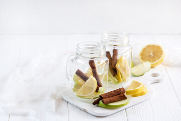 Two glass jars with ingredients for infused water on wooden board Detox fruit water Copy space