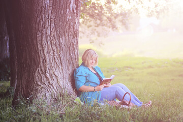 female in the park on sunset with book