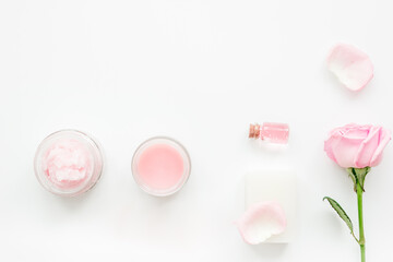 rose organic cosmetics with salt, cream and oil on white table background top view